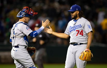 El receptor Yasmani Grandal (9) y el lanzador Kenley Jansen (74) de los Dodgers de Los Ángeles tras la victoria ante los Atléticos de Oakland. (AP)