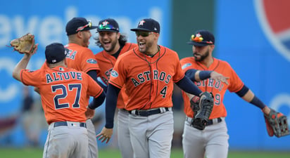 Los jugadores de los Astros George Springer (4) y el venezolano José Altuve se felicitan, mientras sus compañeros empiezan la celebración.