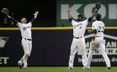 Los jardineros de Cerveceros, celebran Ryan Braun (i), Lorenzo Cain (c) y Christian Yelich celebran el triunfo.