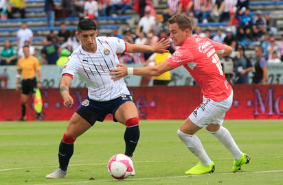 Alan Pulido (i), del Chivas, y Abraham González, del Lobos BUAP, durante el juego en el Estadio Olímpico de la BUAP.