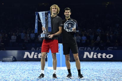 Alexander Zverev y Novak Djokovic sostienen sus respectivos trofeos.