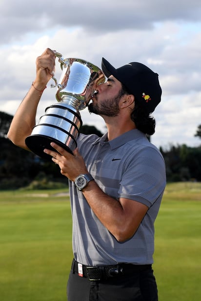 El mexicano Abraham Ancer besa el trofeo luego de ganar el Abierto de Australia, ayer, en Sydney.