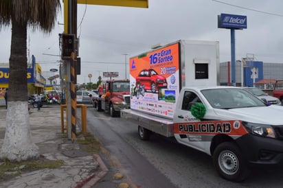 Los comerciantes, sus anunciantes y botargas abordaron los vehículos y realizaron el recorrido por las principales calles de Monclova, llevando en la plataforma de una grúa el automóvil que será rifado. (EL SIGLO COAHUILA)