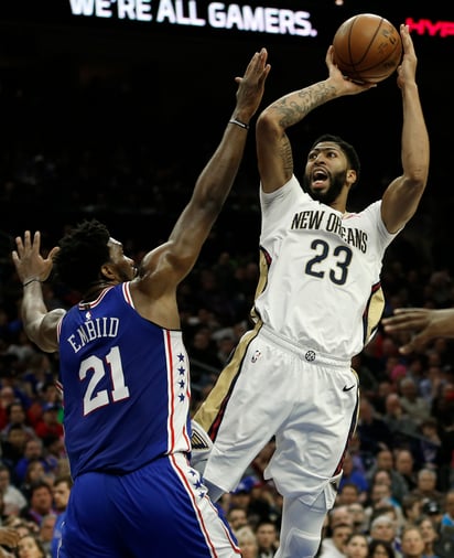 El ala-pívot de los Pelicans de Nueva Orleáns, Anthony Davis (23), intenta un tiro sobre la marcación del pívot de los 76ers de Filadelfia, Joel Embiid (21), en la primera mitad de un juego de la NBA.