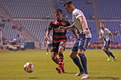 Antonio Nava (i), del Tijuana, y Daniel Arreola, del Puebla, durante el juego de la Jornada 17 en el estadio Cuauhtemoc. (JAMMEDIA)