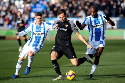 El centrocampista del Leganés Rubén Pérez y su compañero Allan Nyom intentan arrebatar el balón al mediocampista del Sevilla Franco Vázquez.