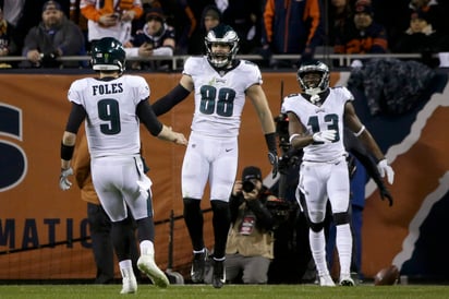 Dallas Goedert (88) festeja con Nick Foles tras anotar en el partido de comodines ante los Bears de Chicago.