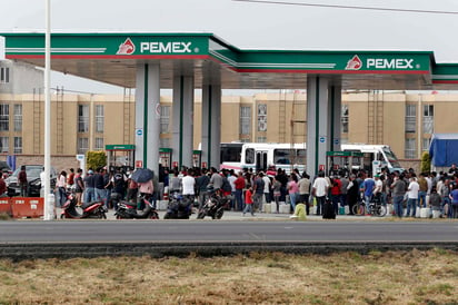 A la espera. En una gasolinera de la autopista México-Pachuca, cerca de la caseta de peaje, automovilistas y personas con bidones hacen largas filas para comprar combustible