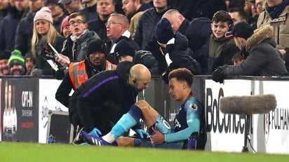 El volante Dele Alli recibe atención médica durante el partido ante Fulham por la Premier League. (AP)