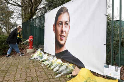 Ramos de flores y otros tributos desplegados cerca de una foto del futbolista argentino Emiliano Sala afuera del predio de entrenamientos del club francés Nantes. (AP) 