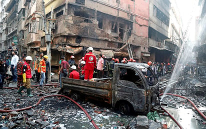 Cenizas. Varios bomberos inspeccionan los escombros tras el incendio en el barrio Chawkbazar. (EFE)