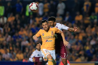 Israel Jiménez (i), de Tigres, y Johan Venegas, de Saprissa, disputan el balón durante el juego de vuelta de los octavos de final.