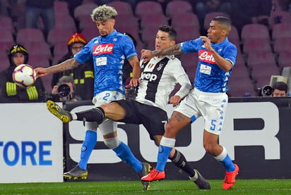 Cristiano Ronaldo (7) lucha por el balón con los jugadores del Napoli, Kevin Malcuit y Allan (5).