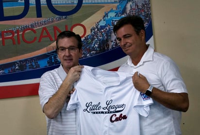 Stephen D. Keener (i), presidente de la organización internacional de las Pequeñas Ligas, le entrega una camiseta a Antonio Castro, el hijo del fallecido presidente cubano Fidel Castro.