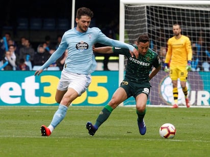 El centrocampista turco del Celta Okay Yokuslu (i) pelea un balón con el centrocampista mexicano del Betis Andrés Guardado en el partido de Liga que se disputa hoy en el estadio de Balaídos.