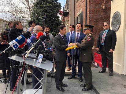 El 'embajador' enviado por Guaidó, Carlos Vecchio (Cen.), entrega la bandera venezolana al coronel José Luis Silva Silva (Der.) junto a representantes militares y diplomáticos tras tomar el control de la agregaduría militar naval y aérea, en Washington, DC. (EFE)