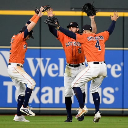 Josh Reddick (i), Jake Marisnick (c) y George Springer, de los Astros de Houston, realizan una celebración al estilo del videojuego Fortnite.