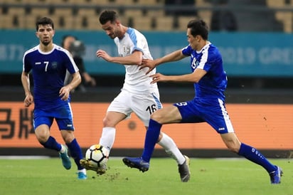 El defensa Martín Cáceres (c) en acción ante Jaloliddin Masharipov durante el partido de la China Cup que enfrentó a Uruguay y Uzbekistán, en Nanning.