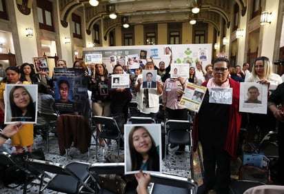 Durante la Reinstalación del Sistema Nacional de Búsqueda, ayer en Palacio Nacional, asistentes mostraron fotos de sus familiares desaparecidos. (NOTIMEX)