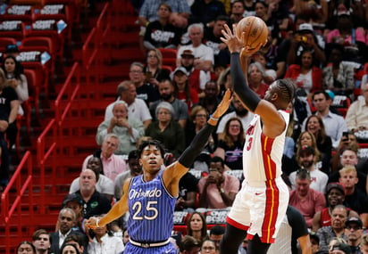 El escolta del Heat de Miami Dwyane Wade hace un tiro sobre la marcación de Wesley Iwundu, durante un juego de este martes.