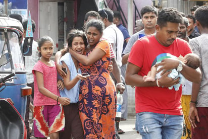 Varias personas corrieron para ponerse a salvo mientras las autoridades evacuaron los alrededores de la iglesia de San Antonio en Colombo, donde localizaron una furgoneta con explosivos. (EFE)