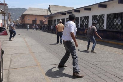 Con piedras, palos, machetes y bombas caseras, se liaron esta tarde ambos grupos antagónicos que dejaron al menos tres personas lesionadas. (EFE)