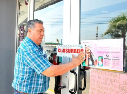 El coordinador de Ecología fija el sello de clausura en Aguillón sucursal Pape y Ecuador en el fraccionamiento Carranza. (EL SIGLO DE TORREÓN)