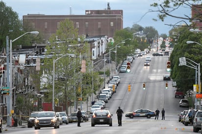 Policías trabajan cerca del lugar en el que, según las autoridades, varias personas fueron baleadas, al menos una de muerte, ayer en Baltimore. (EFE)