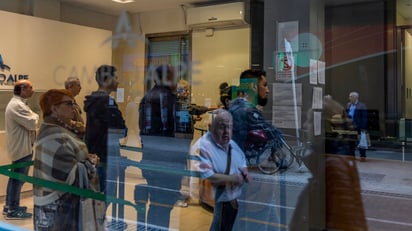 La gente hace cola en una casa de cambio en Buenos Aires, Argentina. A partir de ayer no habrá techo para el tipo de cambio. (AP)