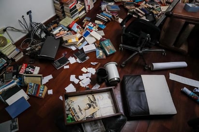 Los libros de la biblioteca que recibe a los visitantes se encontraban todos por los suelos, así como los elementos de cocina, ropa de las habitaciones, los juguetes de sus hijos e incluso fotografías personales. (EFE)