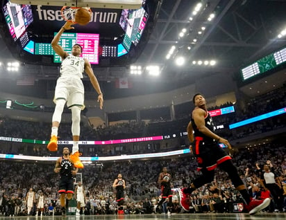 Giannis Antetokounmpo clava el balón durante el duelo de ayer ante los Raptors de Toronto.(AP)