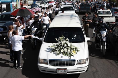 La gente vestida de blanco salió a exigir justicia y paz, formando una cadena humana que acompañó la carroza que trasladó las cenizas del joven y arropó a la familia en su duelo. (NOTIMEX)
