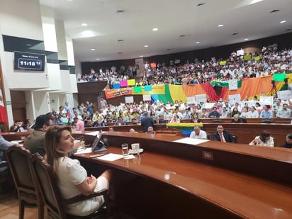 Desde muy temprano, miembros de la comunidad LGBTTTI, con banderas con los colores del arcoíris y pancartas a favor del matrimonio igualitario y respeto a sus derechos, disputaron los espacios, en el salón de sesiones, con miembros del Consejo Religioso Estatal, quienes vistieron con playeras y blusas blancas y portaron cartelones a favor de la familia. (TWITTER)
