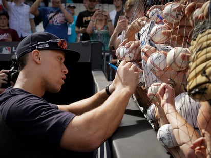 Aaron Judge firma pelotas a los aficionados luego de la práctica de bateo de los Yanquis, en Londres.