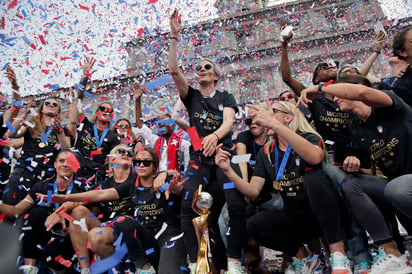 Durante el desfile, y bajo toneladas de confeti, las jugadoras se repartieron en varias de las carrozas y fueron acompañadas por las autoridades locales y estatales. (AP)