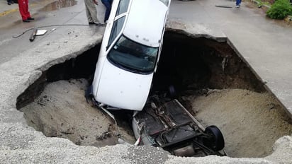 Dos vehículos que cayeron a un socavón de tres metros de profundidad y ocho metros de diámetro que se generó por la madrugada de este viernes en la avenida Manuel Ávila Camacho, a la altura de la colonia El Chamizal en el Estado de México, dejaron como saldo dos lesionados leves que no requirieron hospitalización. (NOTIMEX)