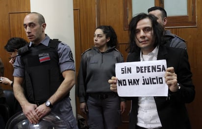 Sentenciado. Cristian Aldana, vocalista de la banda El Otro Yo, posa con un cartel que dice 'Sin defensa no hay juicio'. (ARCHIVO)