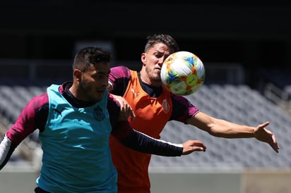 Alexis Vega e Hiram Mier, jugadores del Rebaño Sagrado, durante la práctica de ayer con el equipo. (ESPECIAL)