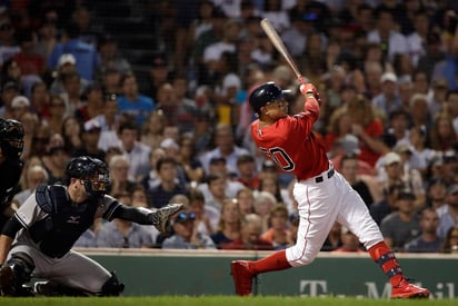 Mookie Betts de los Medias Rojas de Boston dispara un jonrón ante los Yanquis de Nueva York. (AP)