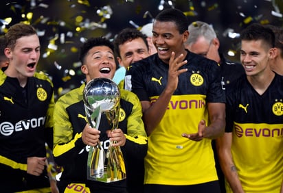 El mediocampista Jadon Sancho (con el trofeo) brilló en el duelo ante los bávaros con gol y asistencia.