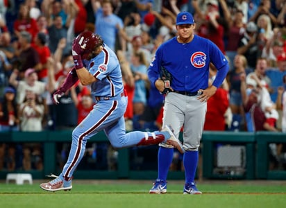 Bryce Harper de los Filis de Filadelfia (i), pasa junto a Anthony Rizzo luego de pegar un grand slam en la novena entrada. (AP)