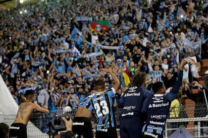 Tras la finalización del encuentro, celebran jugadores del Gremio con sus aficionados.(EFE) 