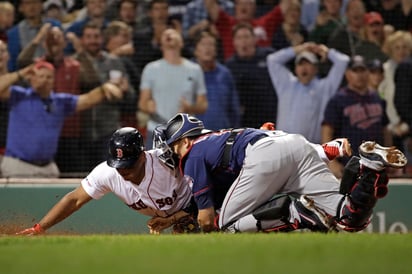 El cátcher Mitch Graver pone out a Rafael Devers, quien intentaba anotar la carrera del empate, en la derrota de Boston 2-1 ante Minnesota. (AP)