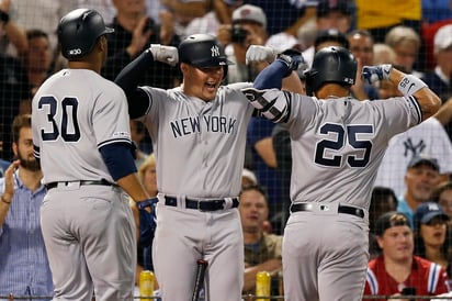 Gleyber Torres (25) festeja con sus compañeros Luke Voit (c) y Edwin Encarnación (30) tras conectar un jonrón de dos carreras ante Boston. (AP)