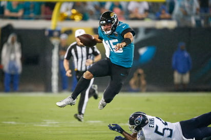 Jalen Ramsey esquiva una tacleada de Rashaan Evans durante el duelo de Jacksonville ante Tennesse. (AP)