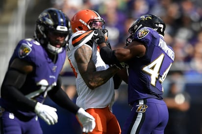 Odell Beckham (c), de los Browns de Cleveland, forcejea con Marlon Humphrey, de los Cuervos de Baltimore, en el juego del domingo. (AP) 