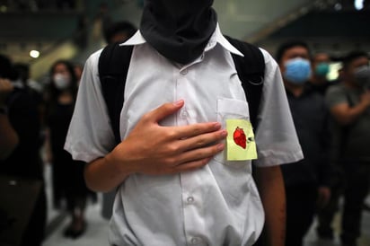 Cientos de personas, incluidos estudiantes, protestaron por la mañana en silenciosa indignación ante la escuela del herido. (EFE)