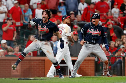 Dansby Swanson (i) y Rafael Ortega celebran tras anotar y darle la vuelta al duelo de ayer ante San Luis. (AP)