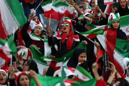 Con banderas iraníes, gorros con los colores nacionales y vuvuzelas, las mujeres comenzaron a animar en un ambiente ensordecedor más de dos horas antes de que arrancara el duelo. (AP)