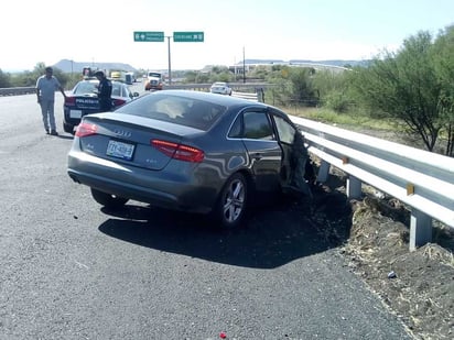 El automóvil Audi de modelo reciente se impactó de frente contra un tráiler cargado con grava.